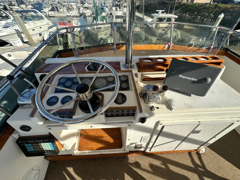 Slide: The Image of 1985 Egg Harbor 33 Sedan helm with steering wheel and navigation equipment. - 13