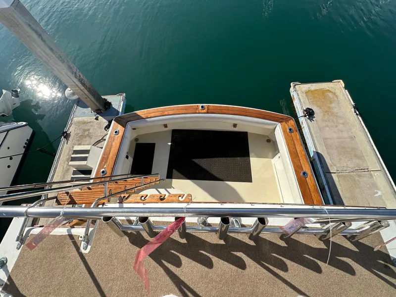 Slide: The Image of 1985 Egg Harbor 33 Sedan boat docked, featuring a spacious deck with wooden trim. - 17