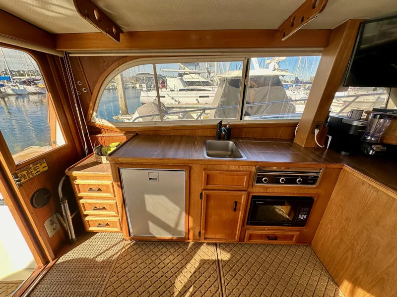 Slide: The Image of Interior of 1985 Egg Harbor 33 Sedan yacht with kitchenette and marina view. - 24