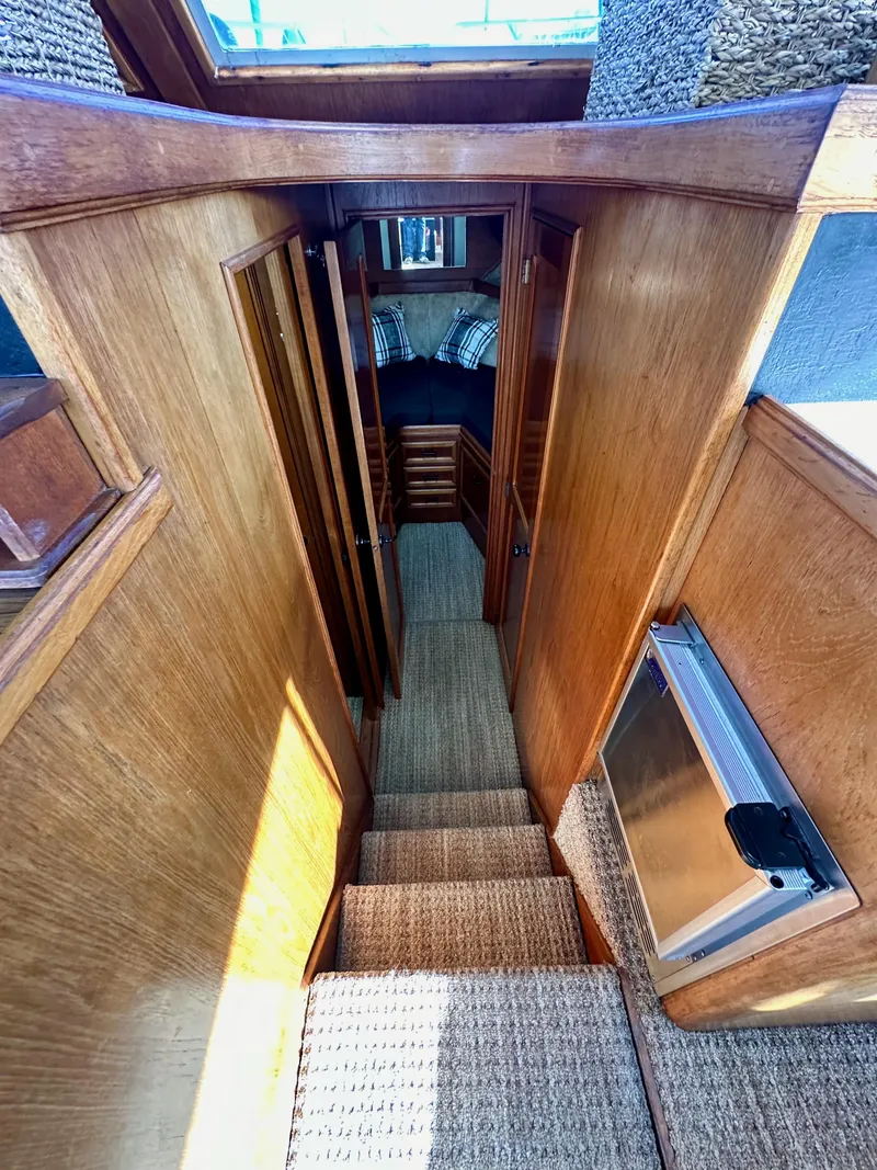 Slide: The Image of Interior view of 1985 Egg Harbor 33 Sedan, featuring wooden stairs and cozy cabin. - 31