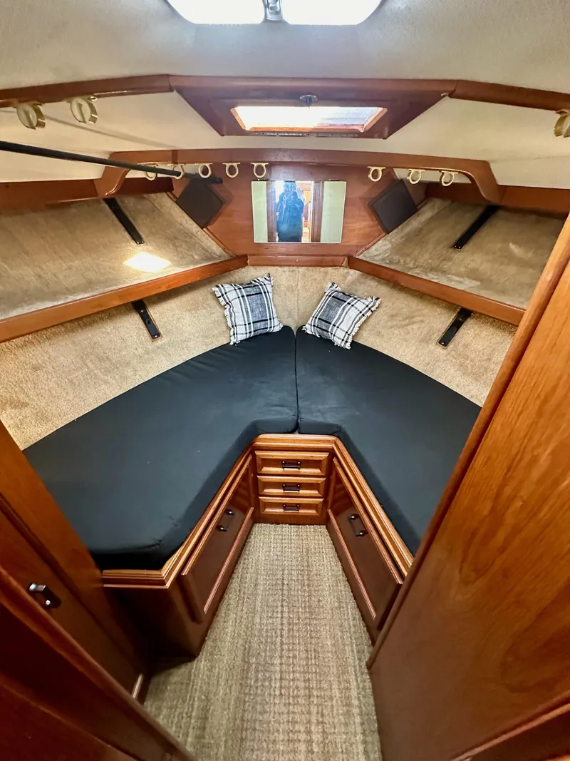 Slide: The Image of 1985 Egg Harbor 33 Sedan cabin with cozy V-berth, wood accents, and plaid pillows. - 37