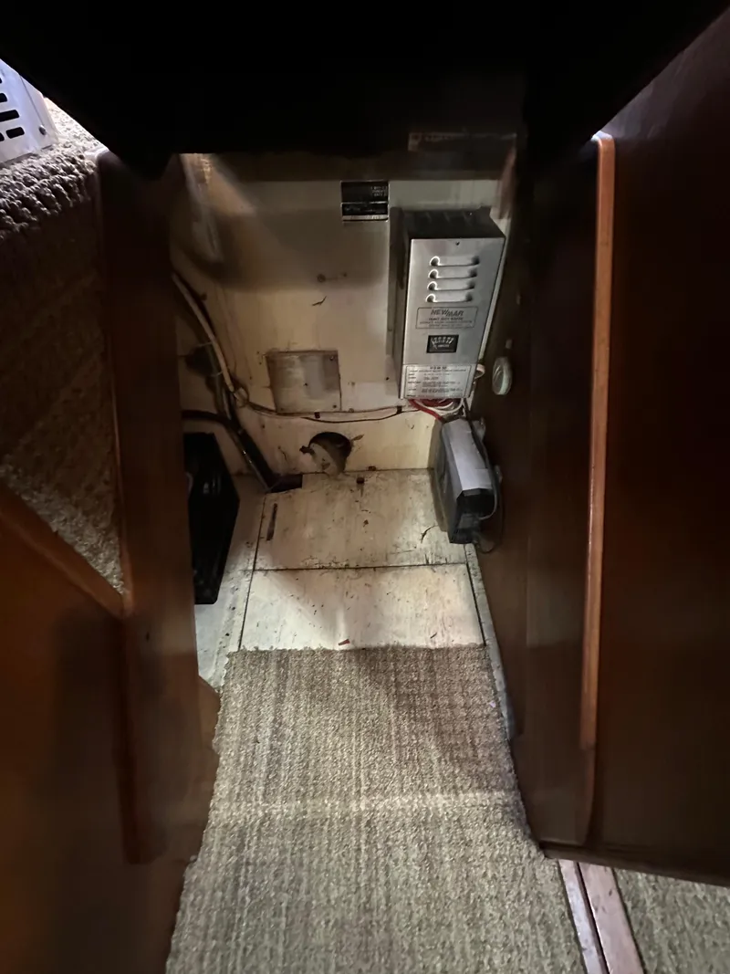 Slide: The Image of Interior view of 1985 Egg Harbor 33 Sedan boat, showing electrical panel and carpeted flooring. - 42