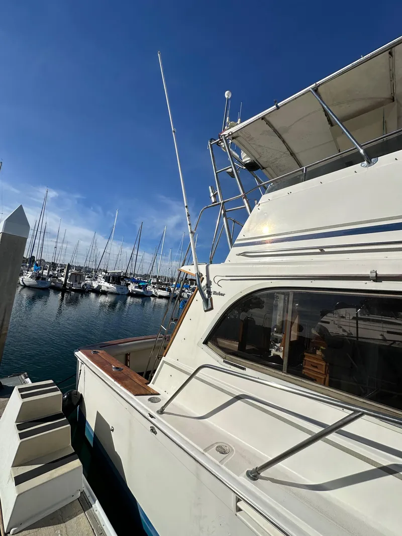 Slide: The Image of 1985 Egg Harbor 33 Sedan boat docked at marina under clear blue sky. - 5