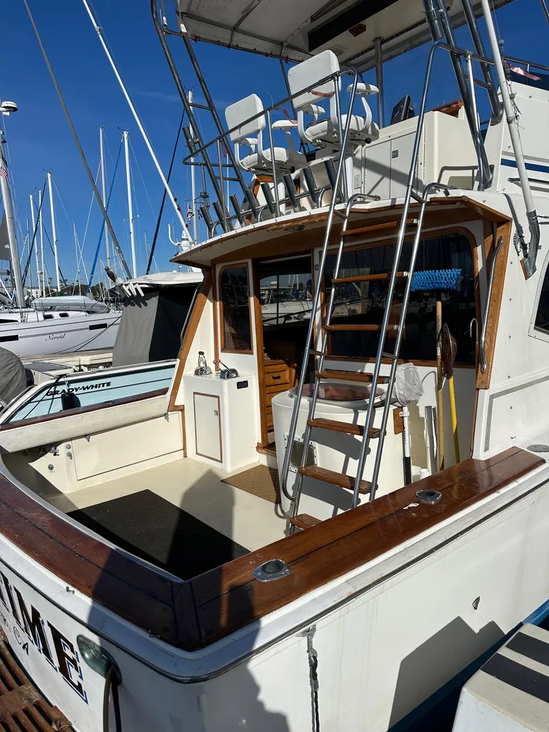 Slide: The Image of 1985 Egg Harbor 33 Sedan boat with upper deck seating and wooden trim in marina. - 7