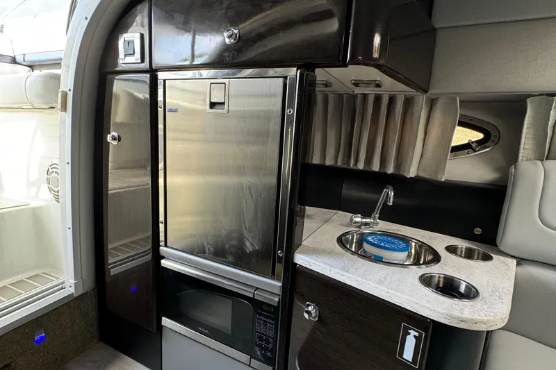 Slide: The Image of 2018 Formula 310SS boat interior with kitchenette, stainless steel fridge, and sink. - 33