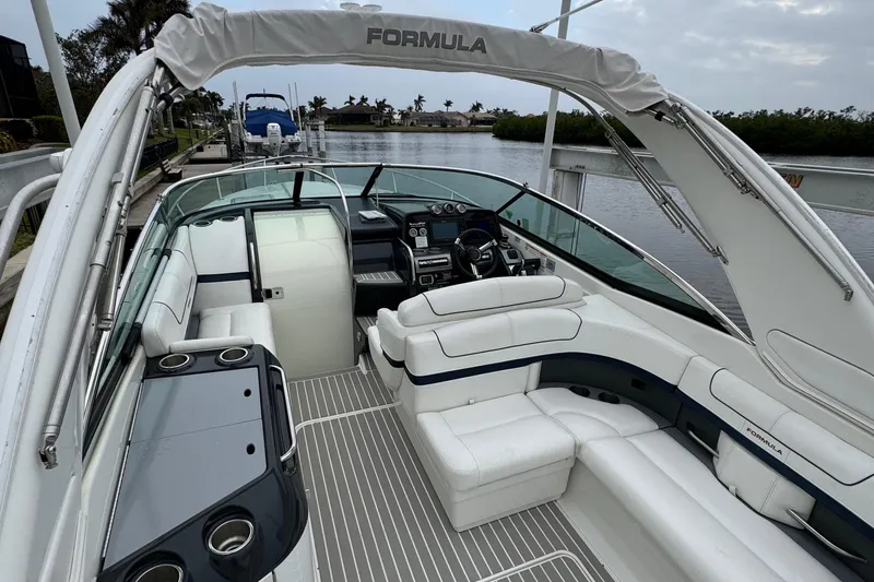 Slide: The Image of 2018 Formula 310SS boat with luxurious seating and sleek design on a calm waterway. - 9