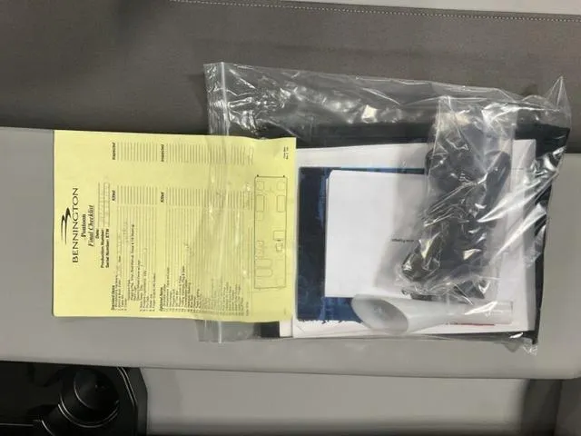 Slide: The Image of Bennington 23 SL 2025 model documents in plastic bag on seat. - 13