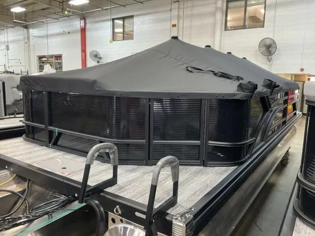 Slide: The Image of 2025 Bennington 23 SL pontoon boat with cover in a warehouse setting. - 14