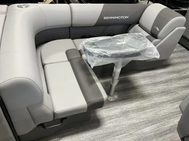 Slide: The Image of 2025 Bennington 23 SL boat interior with gray seating and covered table. - 7