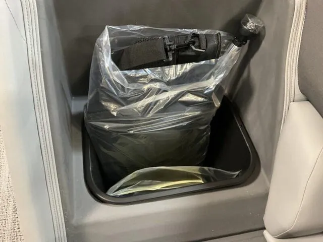 Slide: The Image of Storage compartment in 2025 Bennington 23 SL boat with plastic-wrapped item inside. - 11