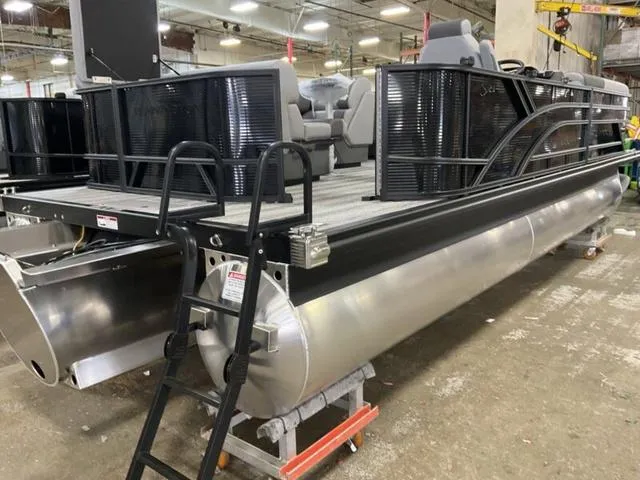 Slide: The Image of 2025 Bennington 23 SL pontoon boat in a warehouse setting. - 12