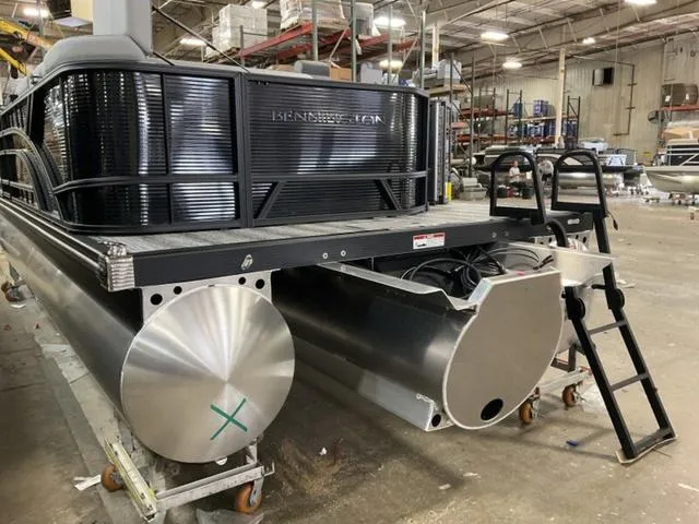 Slide: The Image of 2025 Bennington 23 SL pontoon boat in a warehouse setting. - 13