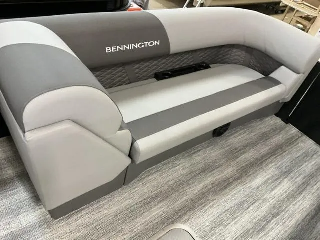Slide: The Image of 2025 Bennington 23 SL boat seating, gray upholstery with logo, on a carpeted floor. - 6