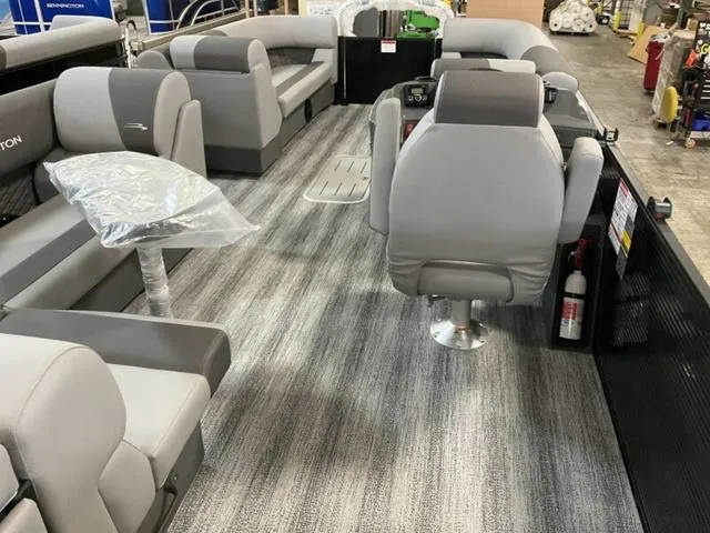Slide: The Image of 2025 Bennington 23 SL pontoon boat interior with gray seating and carpet flooring. - 7