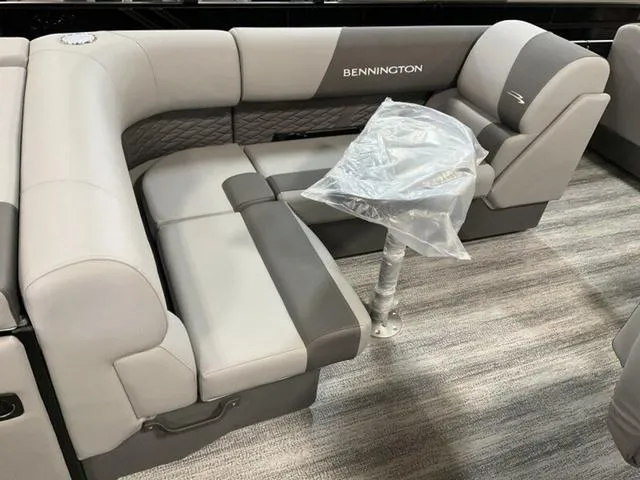 Slide: The Image of 2025 Bennington 23 SL boat interior with gray seating and a covered table. - 8