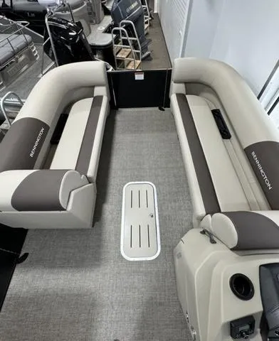 Slide: The Image of 2025 Bennington 23 SL pontoon boat in showroom, featuring sleek black design and spacious seating. - 5