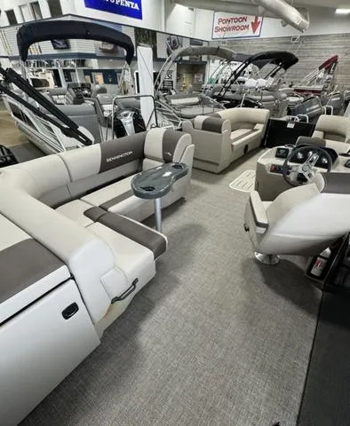 Slide: The Image of 2025 Bennington 23 SL pontoon boat in showroom with modern seating and sleek design. - 8