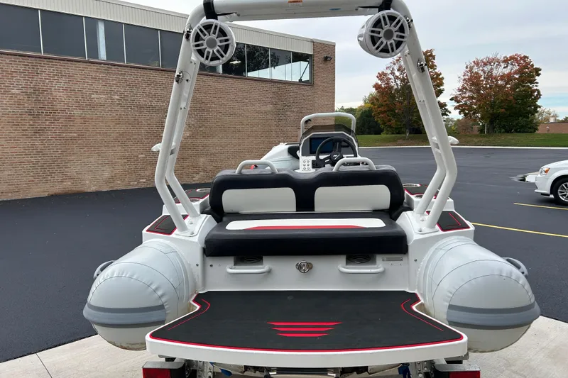 Slide: The Image of 2025 Highfield Velox 420 boat, rear view, parked near a brick building. - 19