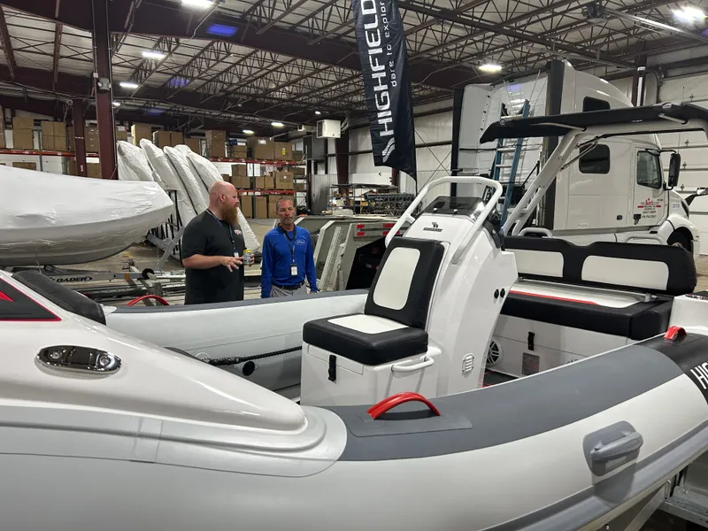 Slide: The Image of 2025 Highfield Velox 420 inflatable boat with modern design, parked outdoors. - 2
