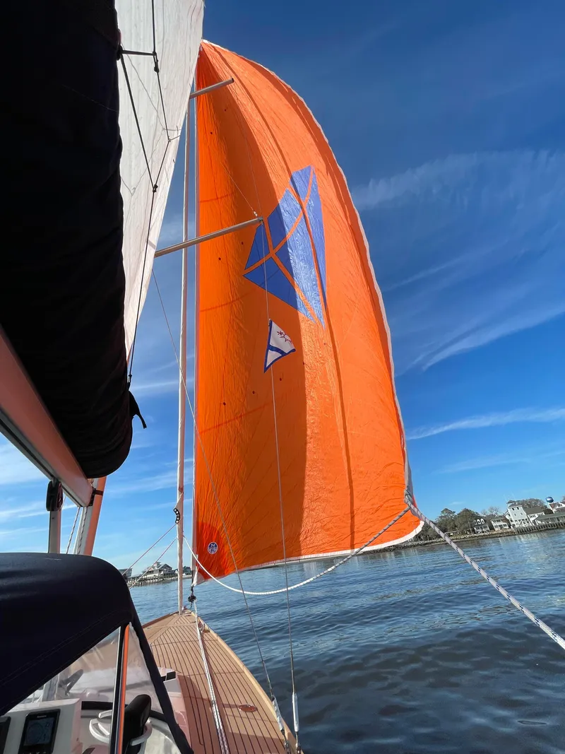 Slide: The Image of 2023 Saffier 8m Open sailboat with vibrant orange sail on a sunny day. - 4