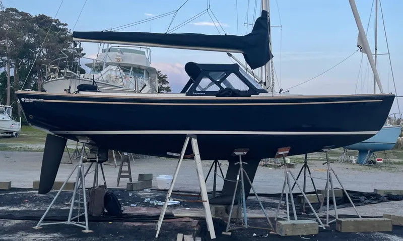 Slide: The Image of 2023 Saffier 8m Open sailboat on stands in a marina setting. - 6