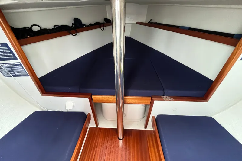 Slide: The Image of Interior of 2023 Saffier 8m Open sailboat with blue cushions and wooden accents. - 9