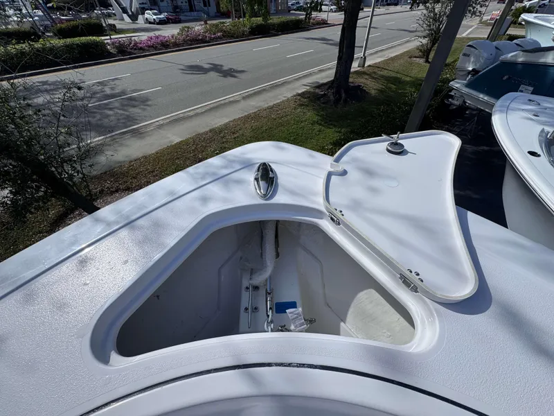 Slide: The Image of 2025 Sportsman 322 Open boat anchor compartment with open hatch, parked near a road. - 10