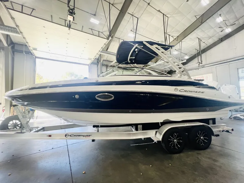Slide: The Image of 2025 Crownline Eclipse E260 XS boat on trailer in indoor showroom. - 0