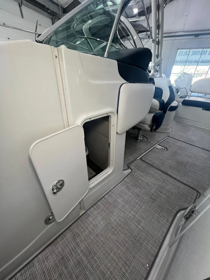 Slide: The Image of 2025 Crownline Eclipse E260 XS interior with open storage compartment. - 18