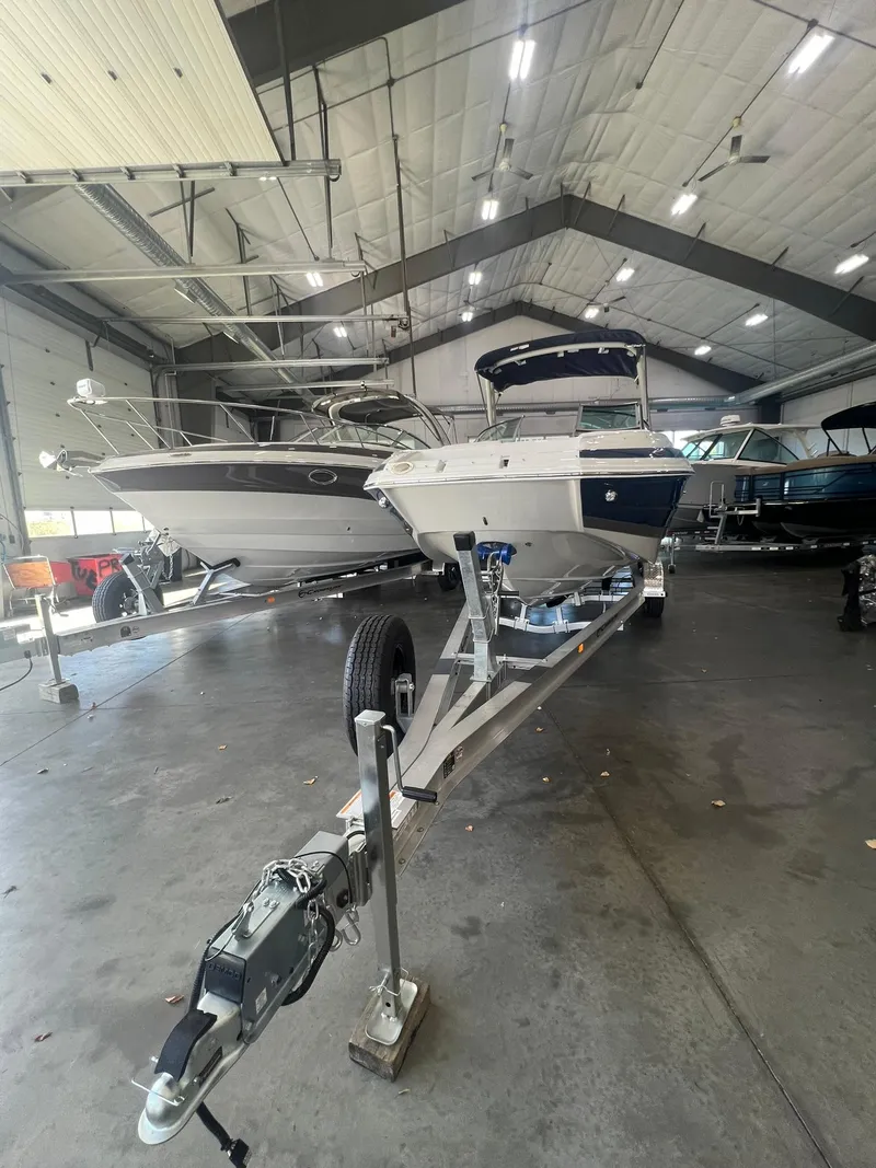 Slide: The Image of 2025 Crownline Eclipse E260 XS boat on trailer in indoor storage facility. - 2