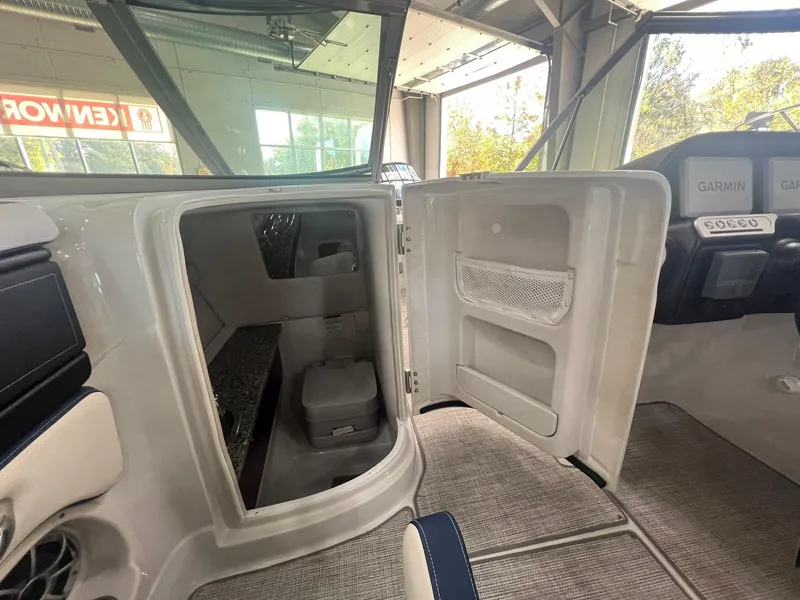 Slide: The Image of 2025 Crownline Eclipse E260 XS boat interior with open cabin door. - 23