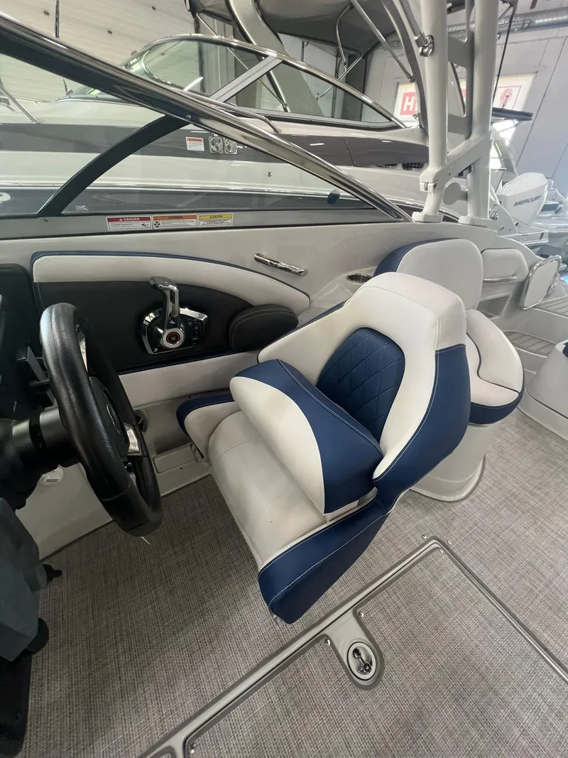 Slide: The Image of 2025 Crownline Eclipse E260 XS boat interior with blue and white seating. - 29