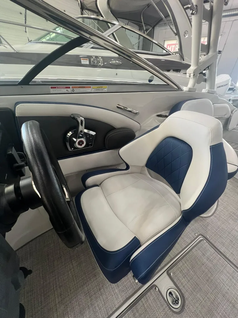 Slide: The Image of 2025 Crownline Eclipse E260 XS boat interior with steering wheel and cushioned seat. - 30