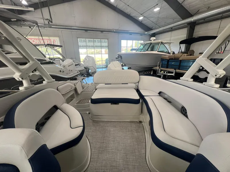 Slide: The Image of 2025 Crownline Eclipse E260 XS boat interior with plush seating in showroom. - 38
