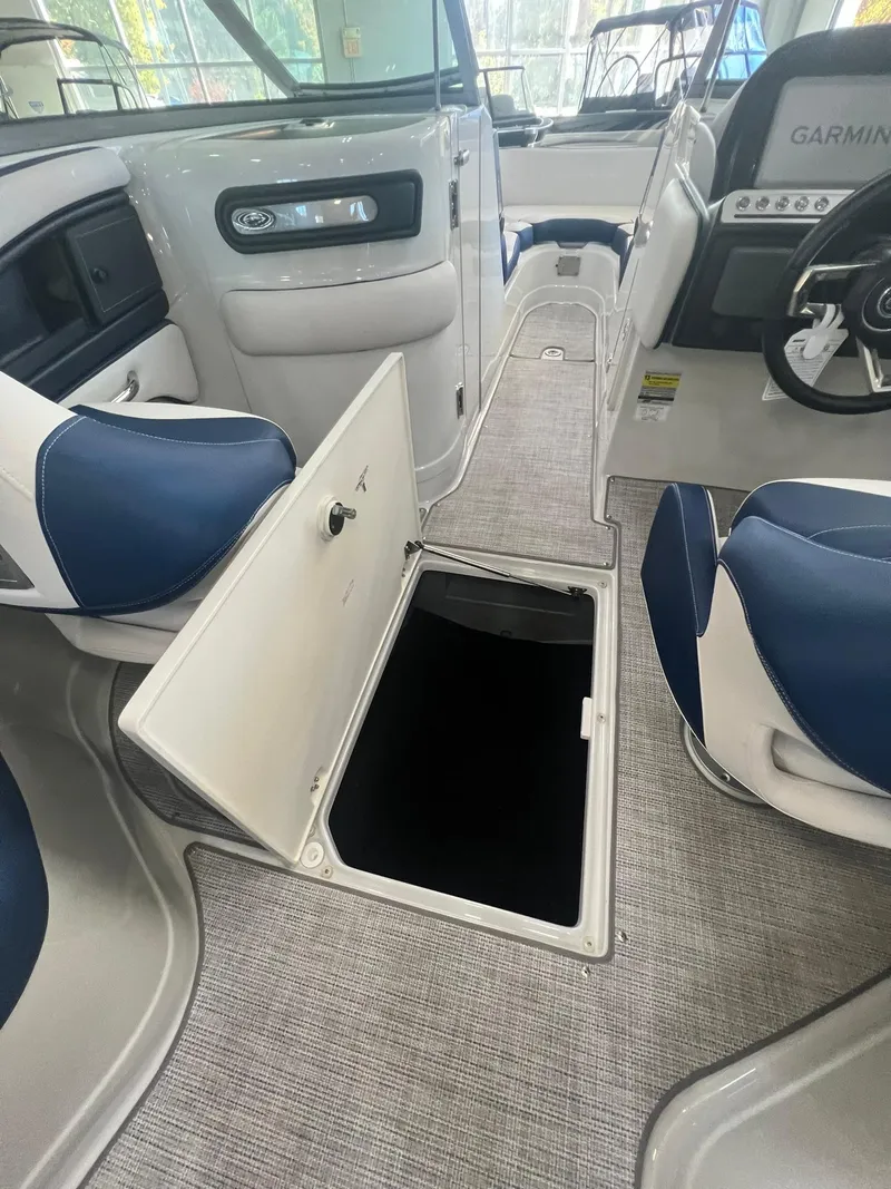 Slide: The Image of 2025 Crownline Eclipse E260 XS boat interior with open storage compartment. - 7