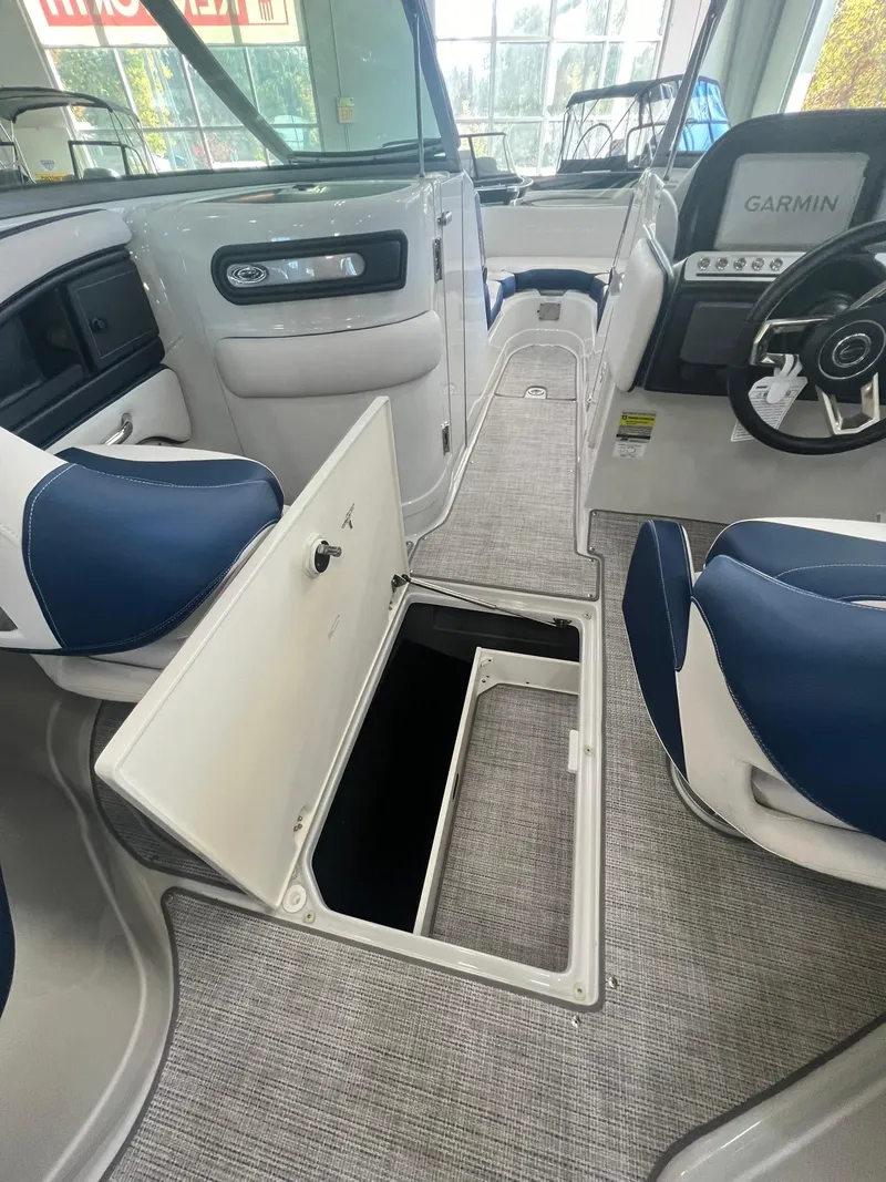 Slide: The Image of 2025 Crownline Eclipse E260 XS boat interior with open storage compartment and modern dashboard. - 8