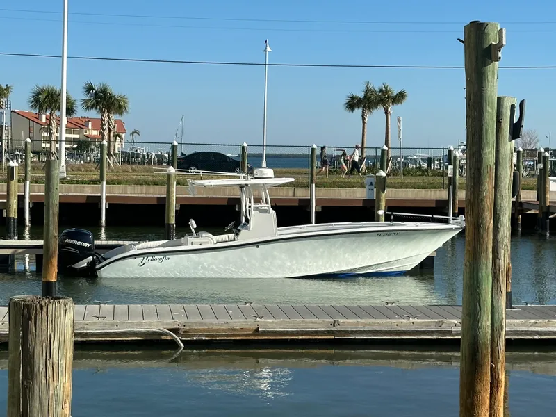 Slide: The Image of 2001 Yellowfin 31 boat docked at marina with palm trees in background. - 0