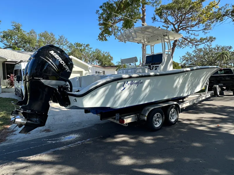 Slide: The Image of 2001 Yellowfin 31 boat on trailer with Mercury outboard motor, parked on residential street. - 11