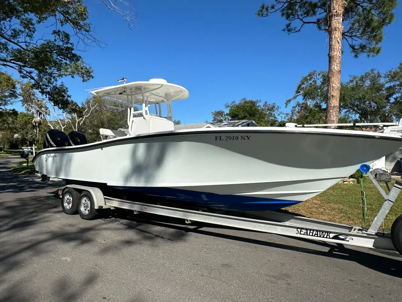 Slide: The Image of 2001 Yellowfin 31 boat on trailer, parked on a sunny street. - 12