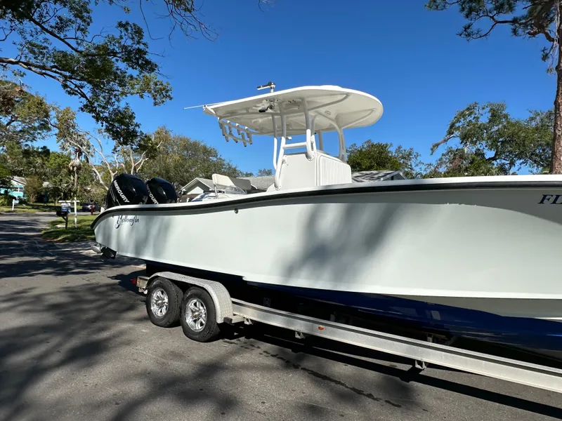 Slide: The Image of 2001 Yellowfin 31 boat on trailer, parked on a sunny street. - 13