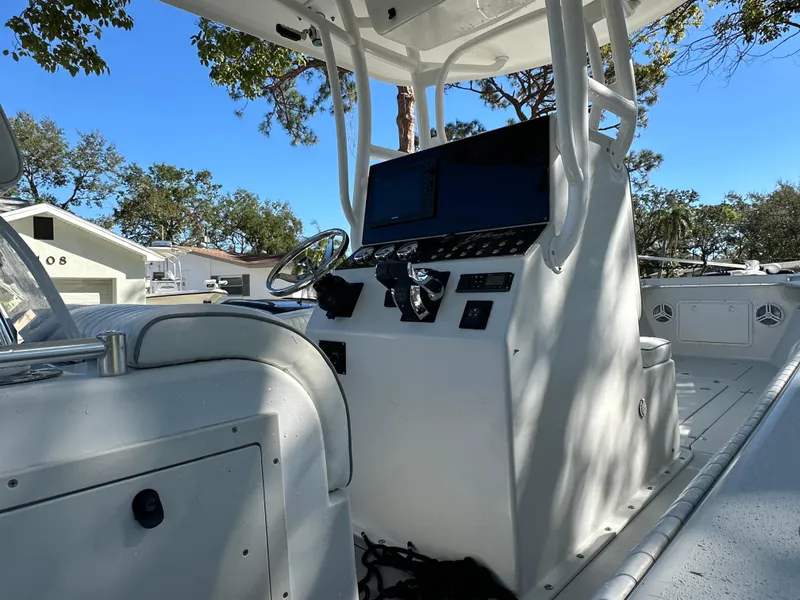 Slide: The Image of 2001 Yellowfin 31 boat cockpit with steering wheel and control panel, surrounded by trees. - 26