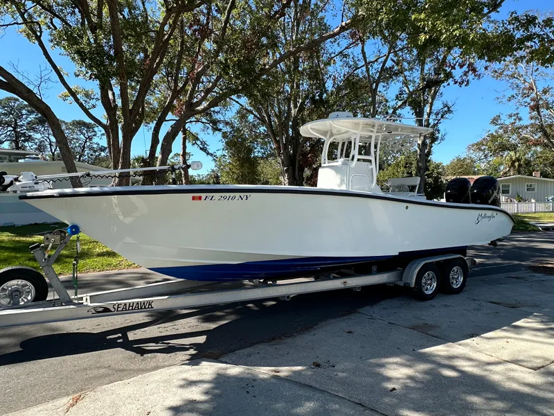 Slide: The Image of 2001 Yellowfin 31 boat on trailer, parked outdoors under trees. - 5