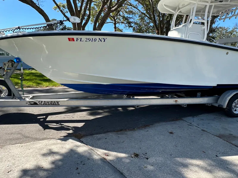 Slide: The Image of 2001 Yellowfin 31 boat on Seahawk trailer, parked on a sunny street. - 6