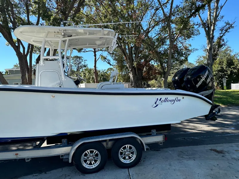 Slide: The Image of 2001 Yellowfin 31 boat on trailer, parked outdoors with trees in background. - 8