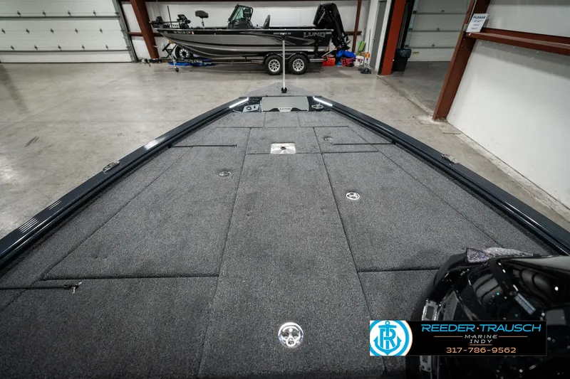 Slide: The Image of 2025 Lund 1875 Pro-V Bass XS boat interior in showroom, featuring spacious deck layout. - 17