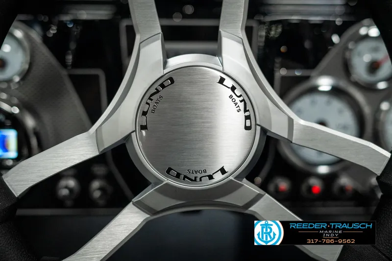 Slide: The Image of Steering wheel of 2025 Lund 1875 Pro-V Bass XS boat, featuring sleek design and branding. - 27