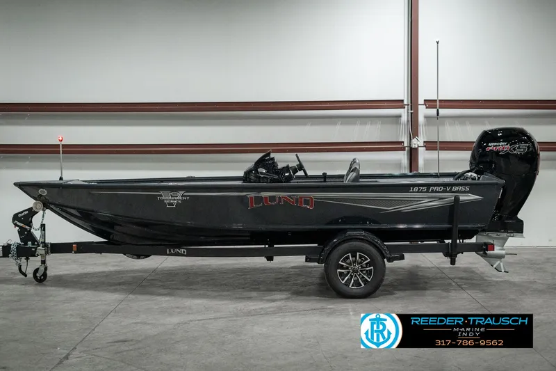 Slide: The Image of 2025 Lund 1875 Pro-V Bass XS boat in a showroom, side view. - 3