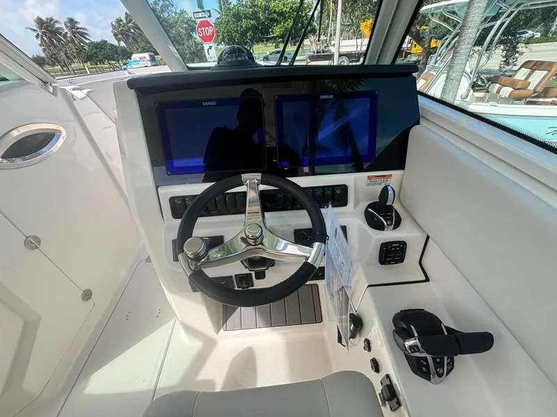 Slide: The Image of 2025 Sailfish 316 DC boat cockpit with dual screens and modern steering wheel. - 12