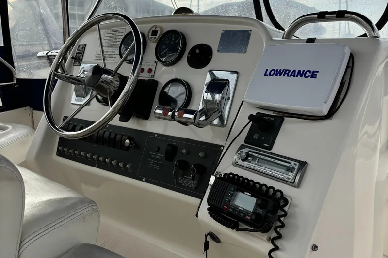 Slide: The Image of 1998 Silverton 352 Motor Yacht helm with steering wheel and navigation equipment. - 19