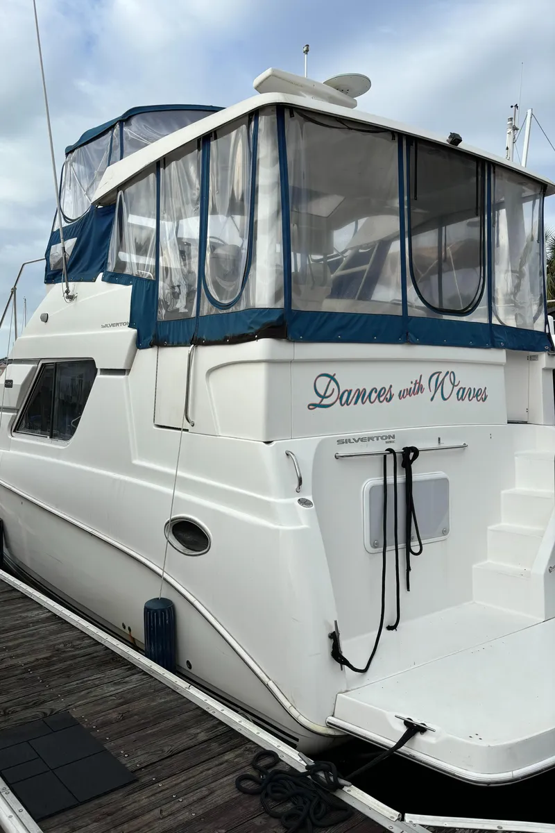Slide: The Image of 1998 Silverton 352 Motor Yacht docked, featuring "Dances with Waves" on the stern. - 2